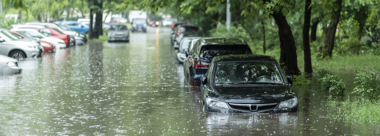 Een straat die onderwater is gelopen met allerlei auto's die onder water staan